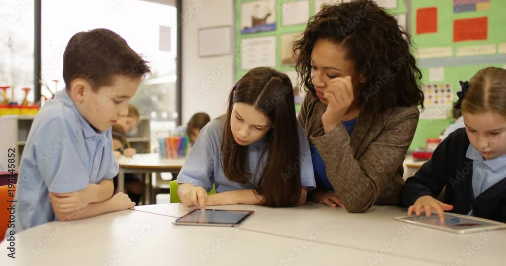 4k, School children with a female teacher working with computers in a classroom. Slow motion. 4k, School children with a female teacher working with computers in a classroom. Slow motion.