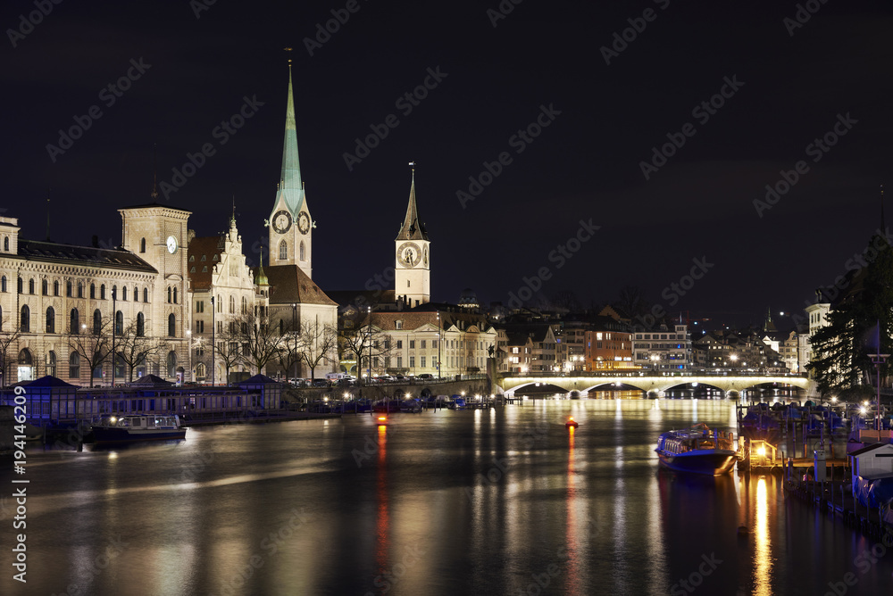 Zürich bei Nacht, Fluss Limmat mit Reflexionen, Stadthaus, Kirchen Fraumünster und St. Peter, Münsterbrücke