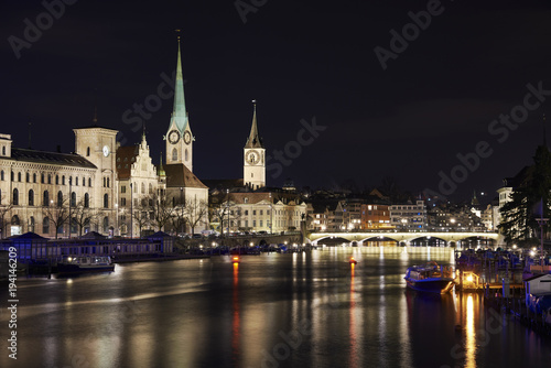 Zürich bei Nacht, Fluss Limmat mit Reflexionen, Stadthaus, Kirchen Fraumünster und St. Peter, Münsterbrücke © paulgsell