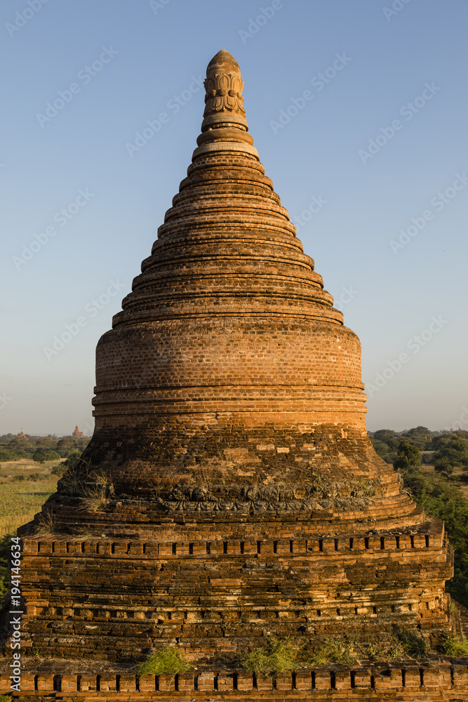 Round, stone stupa of a pagoda in the golden evening light in the pagoda field of Bagan, Myanmar