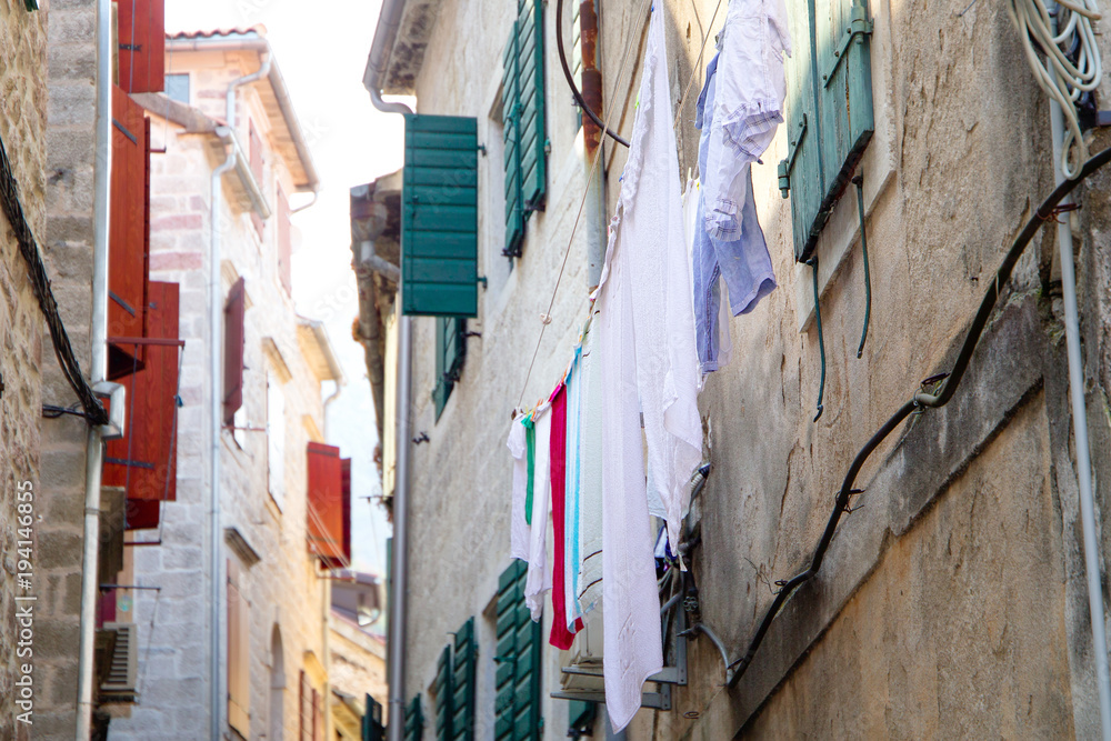 Bed sheets drying in the street, windy hot day. Montenegro, Kotor