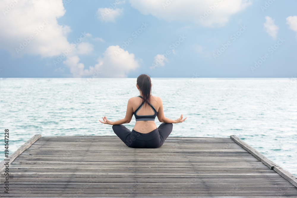 Healthy woman lifestyle meditate balanced yoga practicing and energy on the bridge in morning the seashore. Healthy Concept