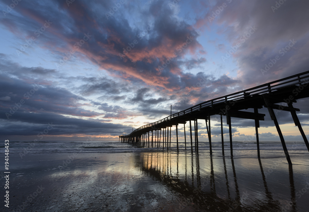 Obraz premium Fishing Pier on Beach with Colorful Sky at Sunrise