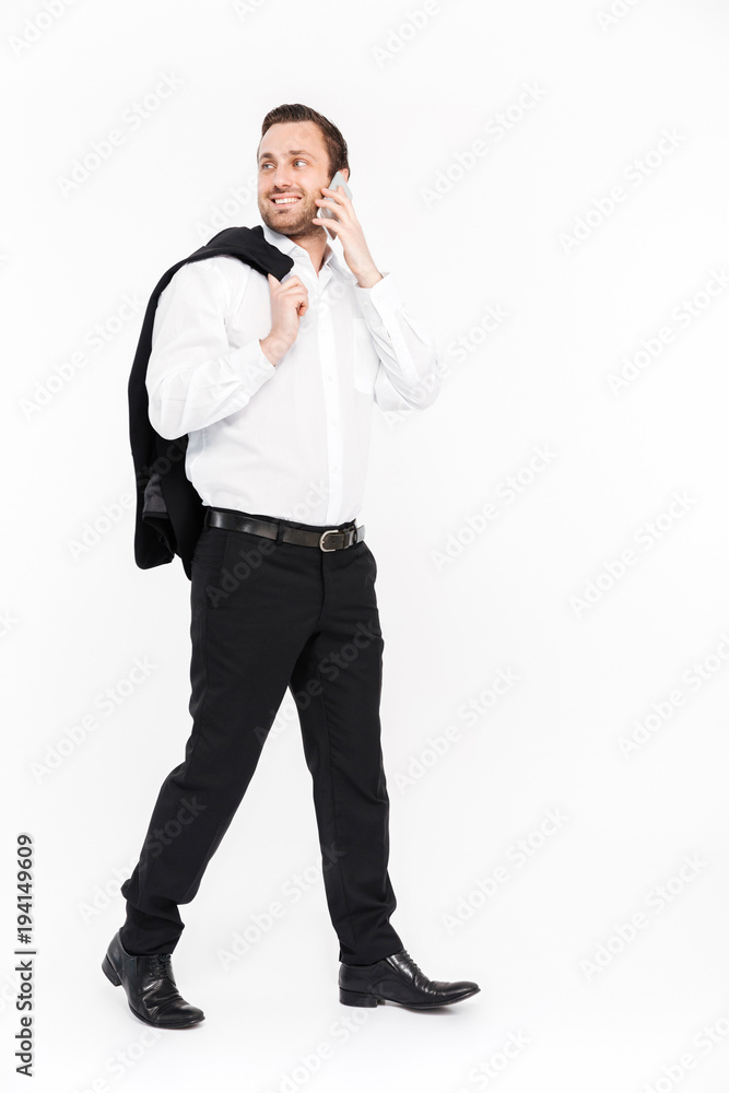 Full-length portrait of businesslike man in black suit talking on mobile phone, isolated in studio over white background Full-length portrait of businesslike man in black suit talking on mobile phone, isolated in studio over white background