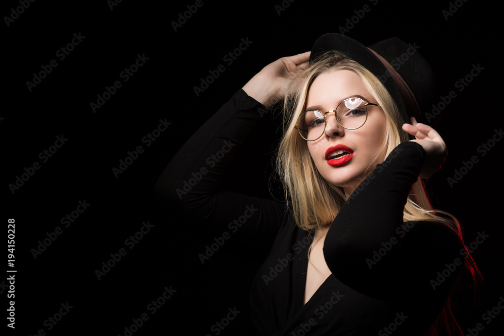 Wonderful young woman wearing black blouse, hat and glasses, posing in the shadow Wonderful young woman wearing black blouse, hat and glasses, posing in the shadow
