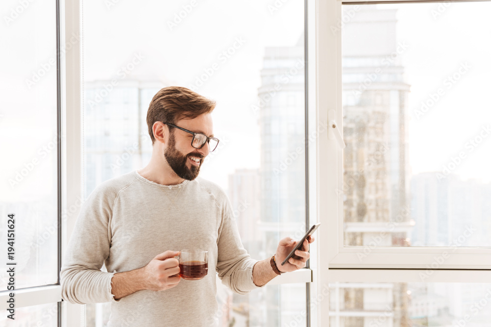 Fototapeta premium Portrait of a smiling man using mobile phone