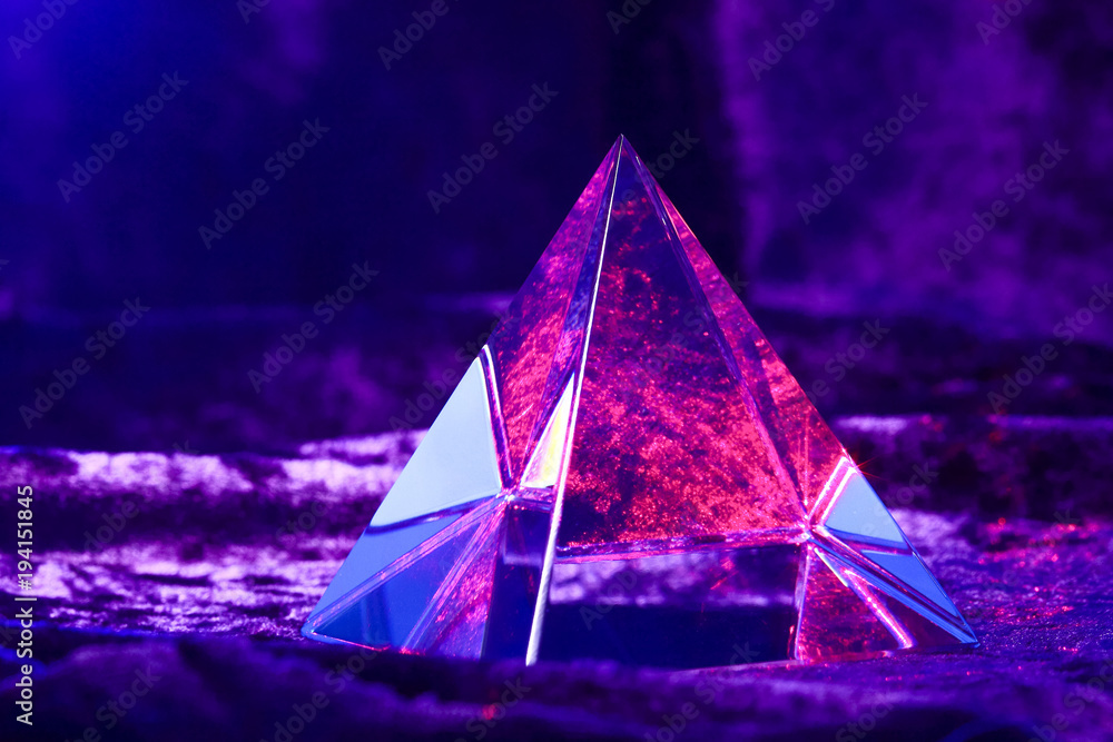Optical glass pyramid lit with a red laser beam and sat on purple velvet  material Stock Photo | Adobe Stock