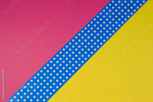 Abstract geometric yellow, pink and blue polka dot paper background.