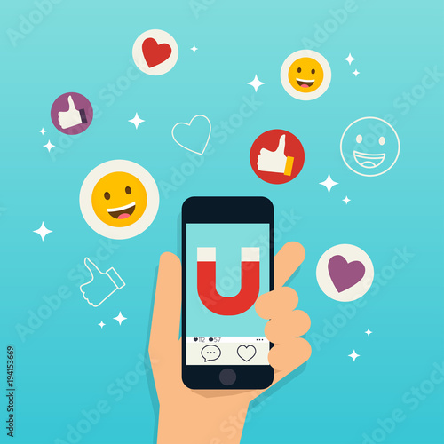 Hand holding mobile smart phone with agnet attracting likes, hearts and reaction smileys. Social media marketing concept.