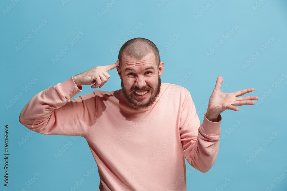 Beautiful male half-length portrait isolated on blue studio backgroud. The young emotional surprised man Beautiful male half-length portrait isolated on blue studio backgroud. The young emotional surprised man