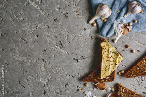 sliced whole wheat bread, chickpea and garlic on the grey concrete backdrop