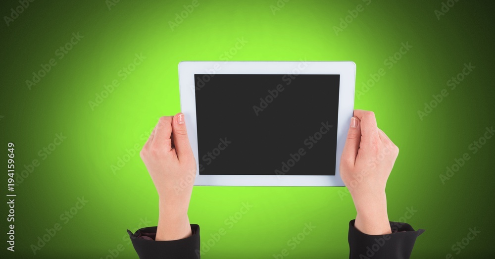 Hand holding tablet with green background Hand holding tablet with green background