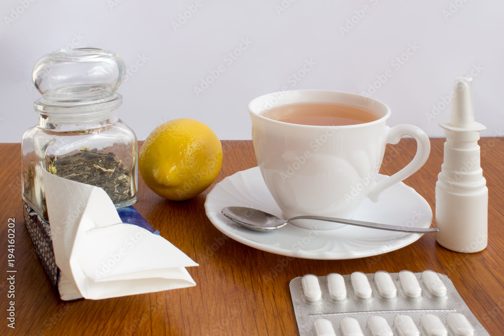 A cup of tea with medicines and a handkerchief A cup of tea with medicines and a handkerchief