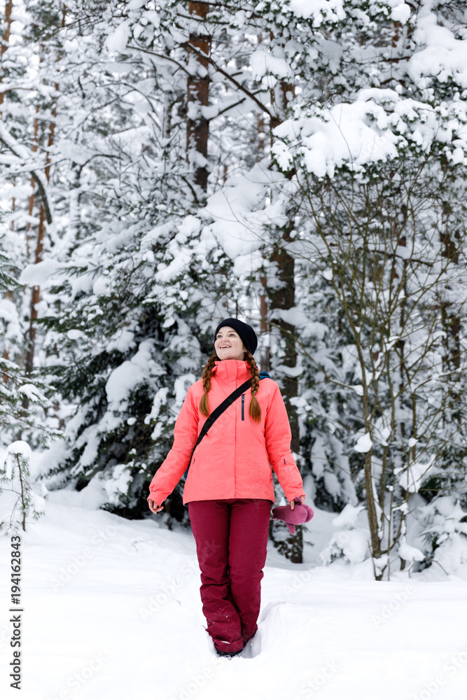 Smiling sport style girl in the winter forest