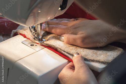 Woman sews red christmas sock