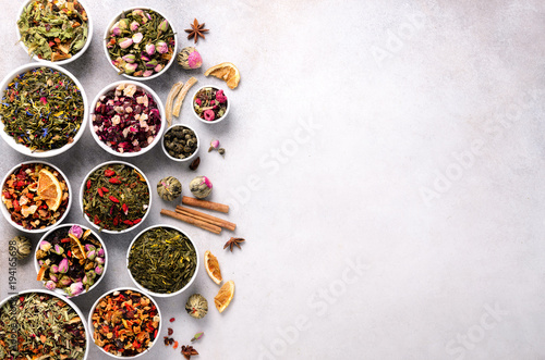 Assortment of dry tea in white bowls. Tea types backgound: green, black, floral, herbal, mint, melissa, ginger, apple, rose, lime tree, fruits, orange, hibiscus, raspberry, cornflower, cranberry