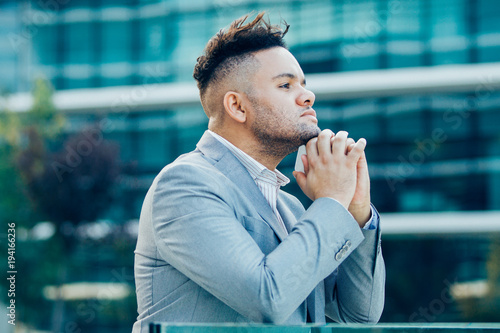 Pensive successful businessman walking in city