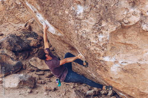 Young Man Bouldering Overhung Cave Outside