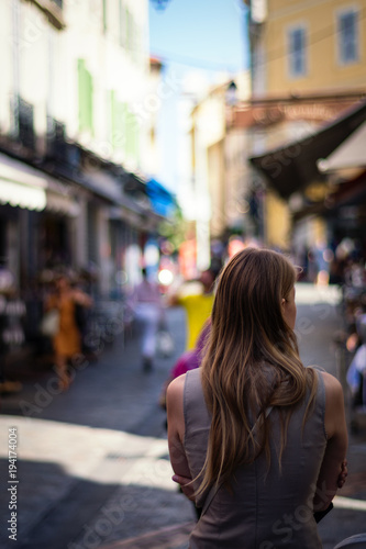 Backside potrait of a middle age brunette long haired woman in front of blurred out city (No face, anonymous)