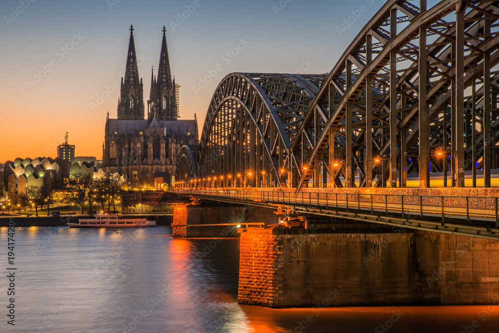 Fototapeta premium Köln – Dom und Hohenzollernbrücke bei Sonnenuntergang