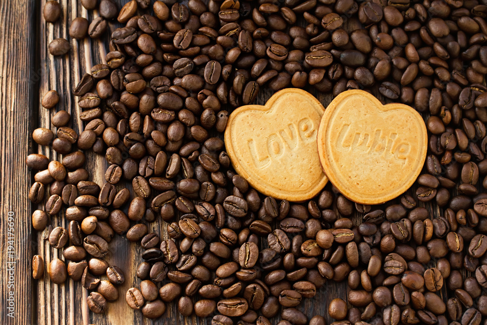 two cookie hearts with the word love on the beans background two cookie hearts with the word love on the beans background