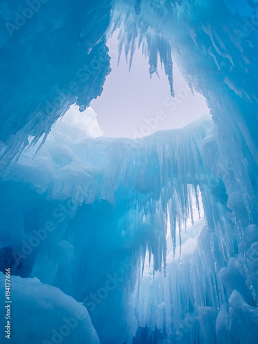 Obraz na plátně Winter ice castle caves with frozen icicles at sunset.