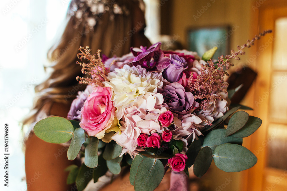 Bride holds in her hands bouquet of pink flowers
