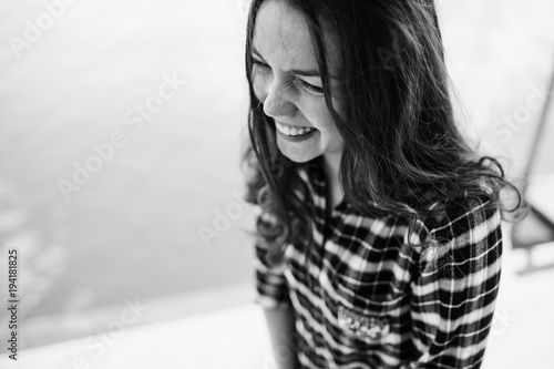 Lovely woman with shiny eyes sits on the porch and smiles