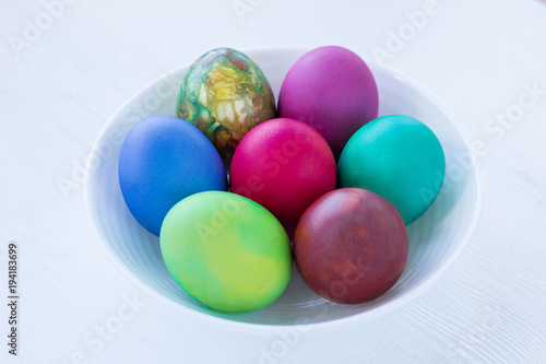 White plate of Easter multicolored boiled eggs decoration isolated