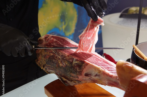 Sliced dried chamon prosciutto. A man cuts a jamon, a warm toned image. Selective focus point. photo