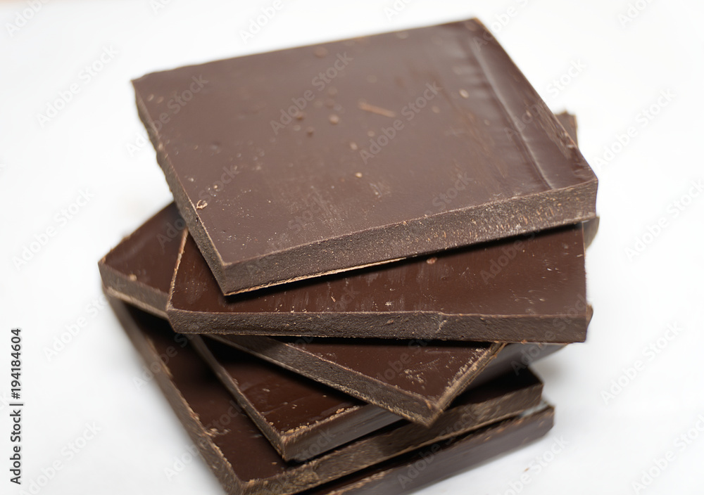 Pieces of dark chocolate on white background. Macro Pieces of dark chocolate on white background. Macro