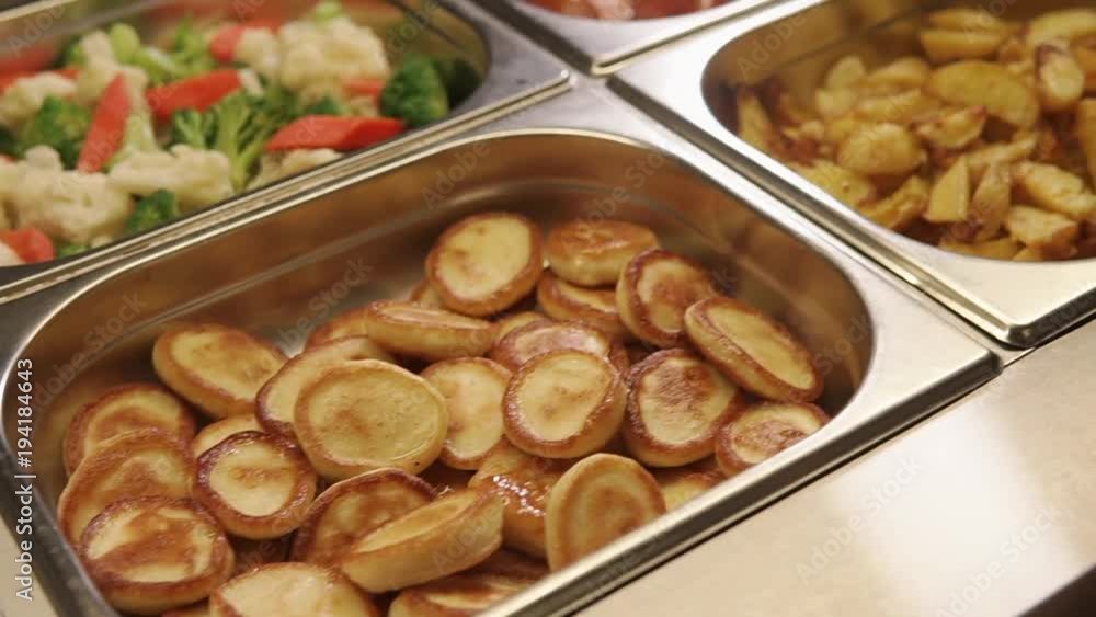 Close up shot of tasty garnish and side dishes in metal food trays in a buffet. Freshly cooked dishes for people. Close up shot of tasty garnish and side dishes in metal food trays in a buffet. Freshly cooked dishes for people.