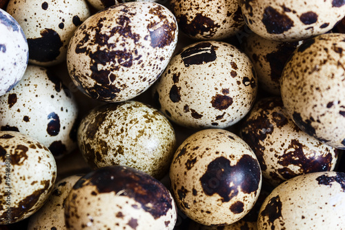 Quail eggs in a clay plate on a wooden background, a plate for storing quail eggs, a symbol of the Easter season. Healthy eating.