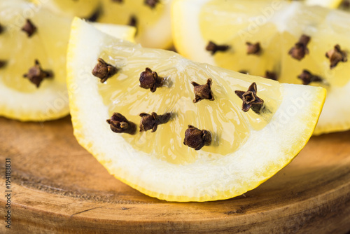 slices of lemon with clove spice, on rustic wood