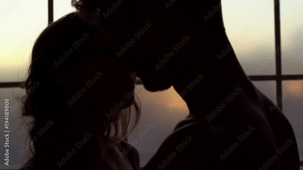 Young couple at home together saint valentine's day concept in the dark kissing close-up