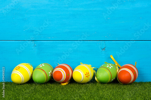 Wooden blue background with easter eggs painted in vibrant colors.