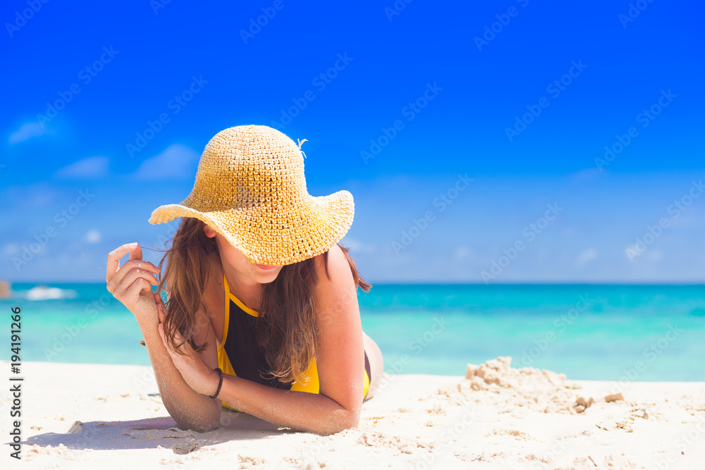 woman in sun hat and swimsuit at beach