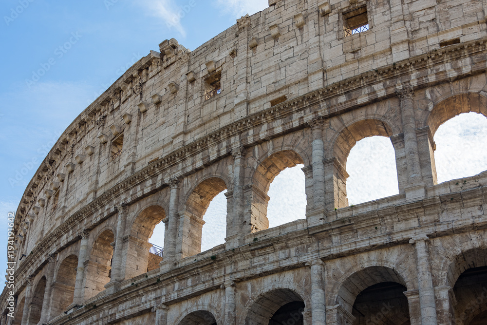 detail view of beautiful architecture of historic colosseum in rome italy on sunny day and clouds