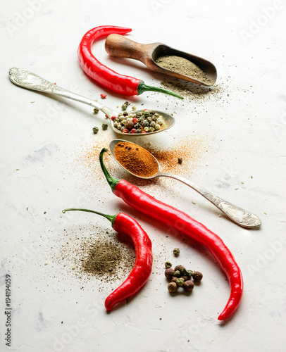 Composition from seasonings and chili pepper. Light stone background from slate. Copy space.