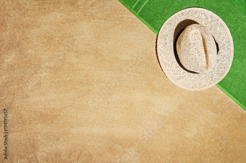 Top view of sandy beach with towel frame and summer accessories. Background with copy space and visible sand texture. Border composition made of towel