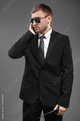 Handsome security guard on grey background