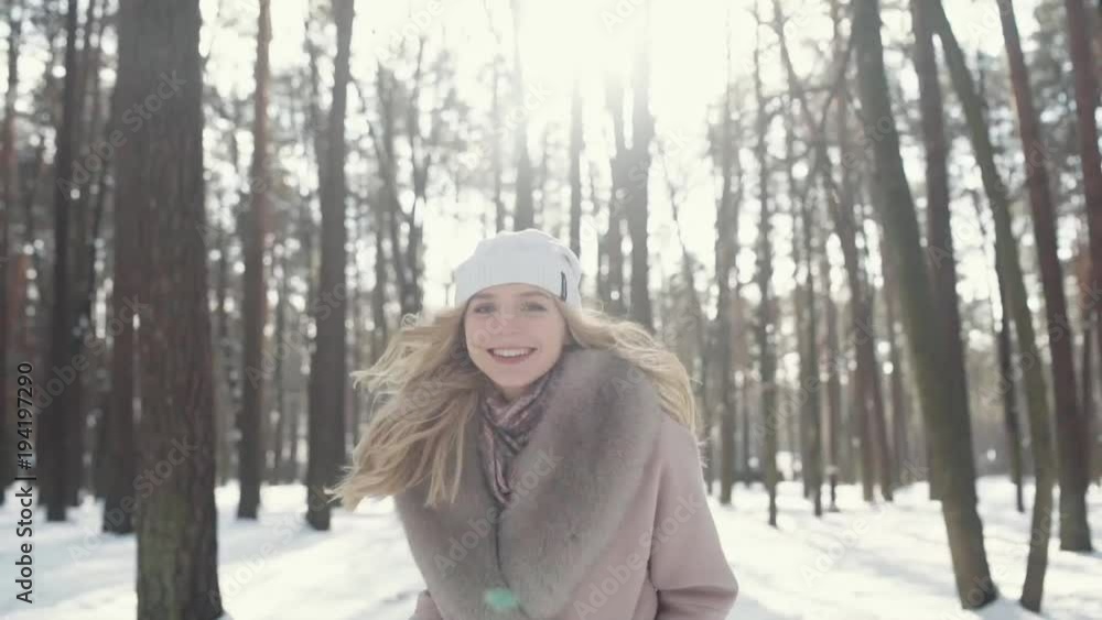 beautiful girl runs through the winter forest in the snow, turns around and laughs beautiful girl runs through the winter forest in the snow, turns around and laughs