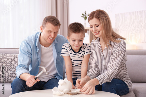Happy family breaking piggy...