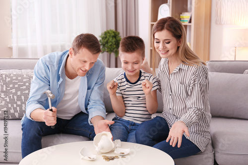 Happy family breaking piggy...