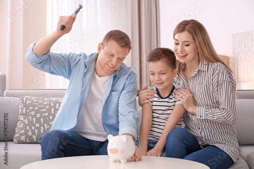 Happy family breaking piggy...
