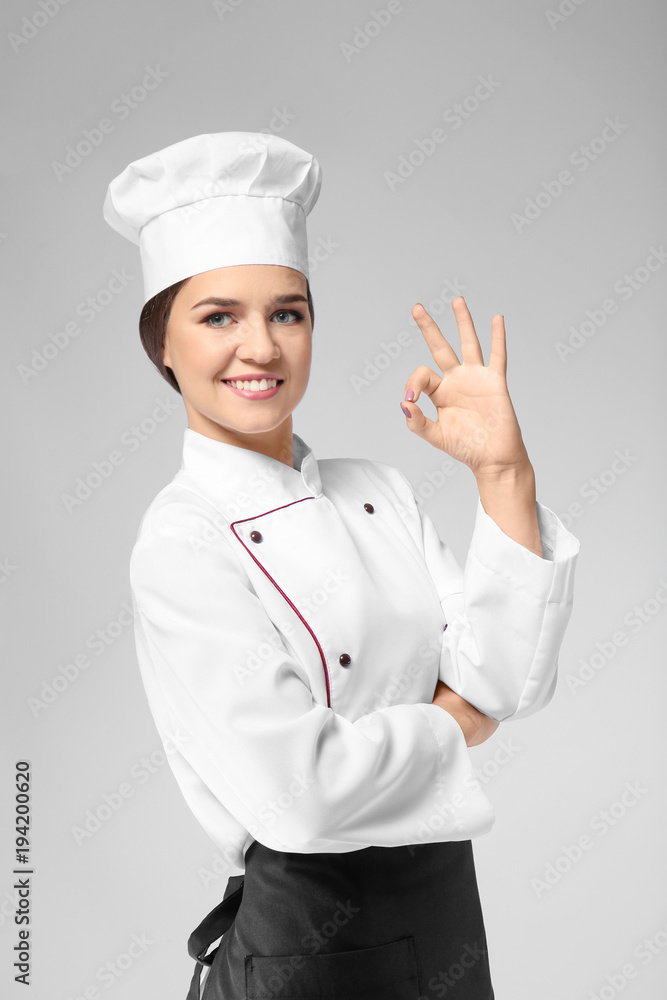 Portrait of female chef on grey background Portrait of female chef on grey background