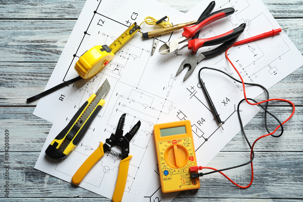 Different electrical tools and circuit diagram on wooden background Different electrical tools and circuit diagram on wooden background