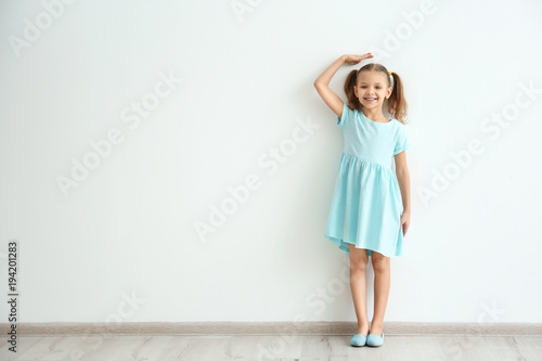 Little girl measuring heigh...