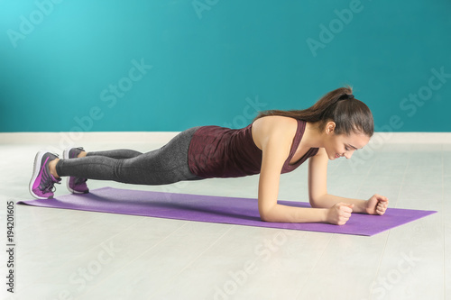 Beautiful young woman doing fitness exercise at home