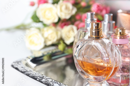 Metal tray with perfume bottles on table